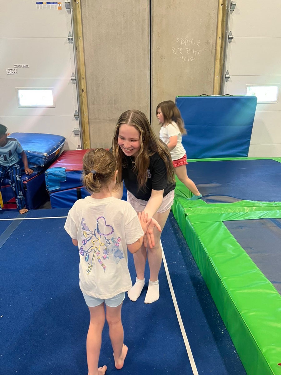 A coach cheering on a young gymnast at Knightdale Gymnastics
