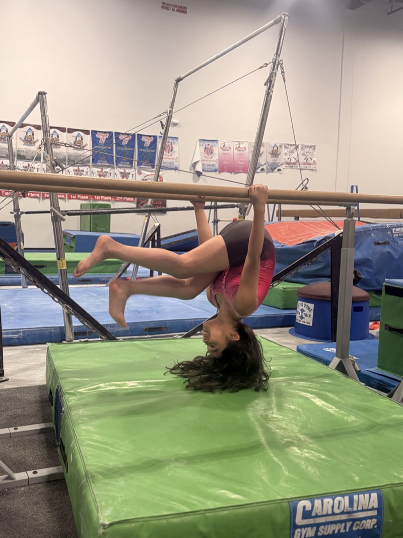 A young gymnast swinging on the bars