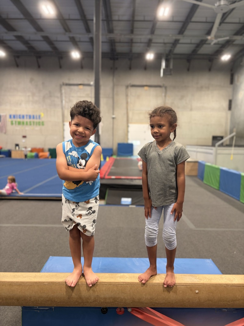 Two young gymnasts on the balance beam